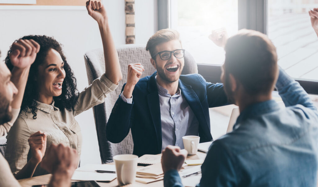 Young business people cheering in a board room